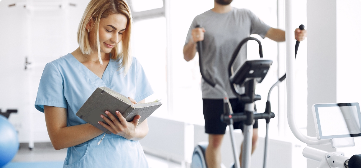 patient-doing-exercise-spin-bike-gym-with-therapist